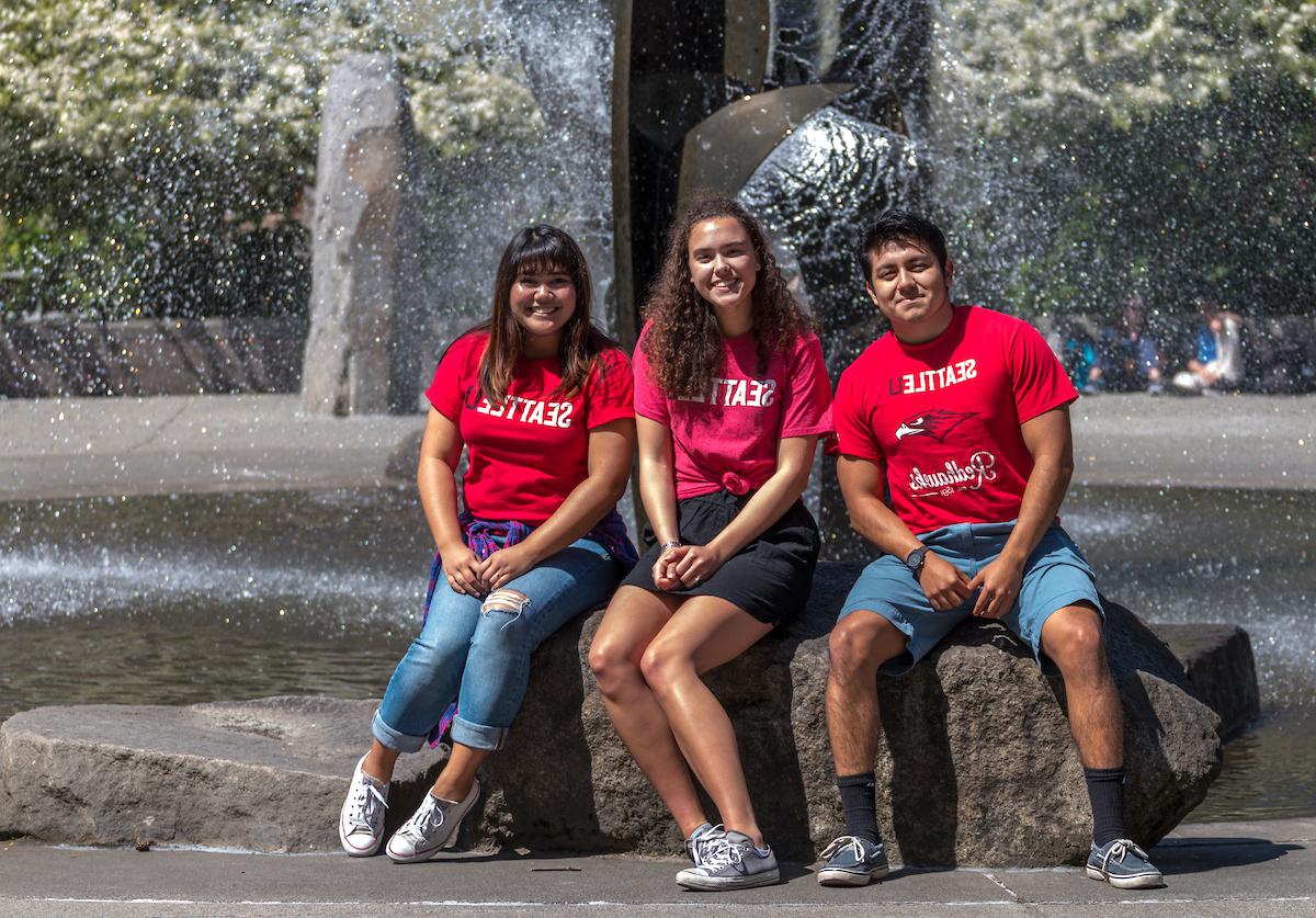 Students sitting in front of fountain